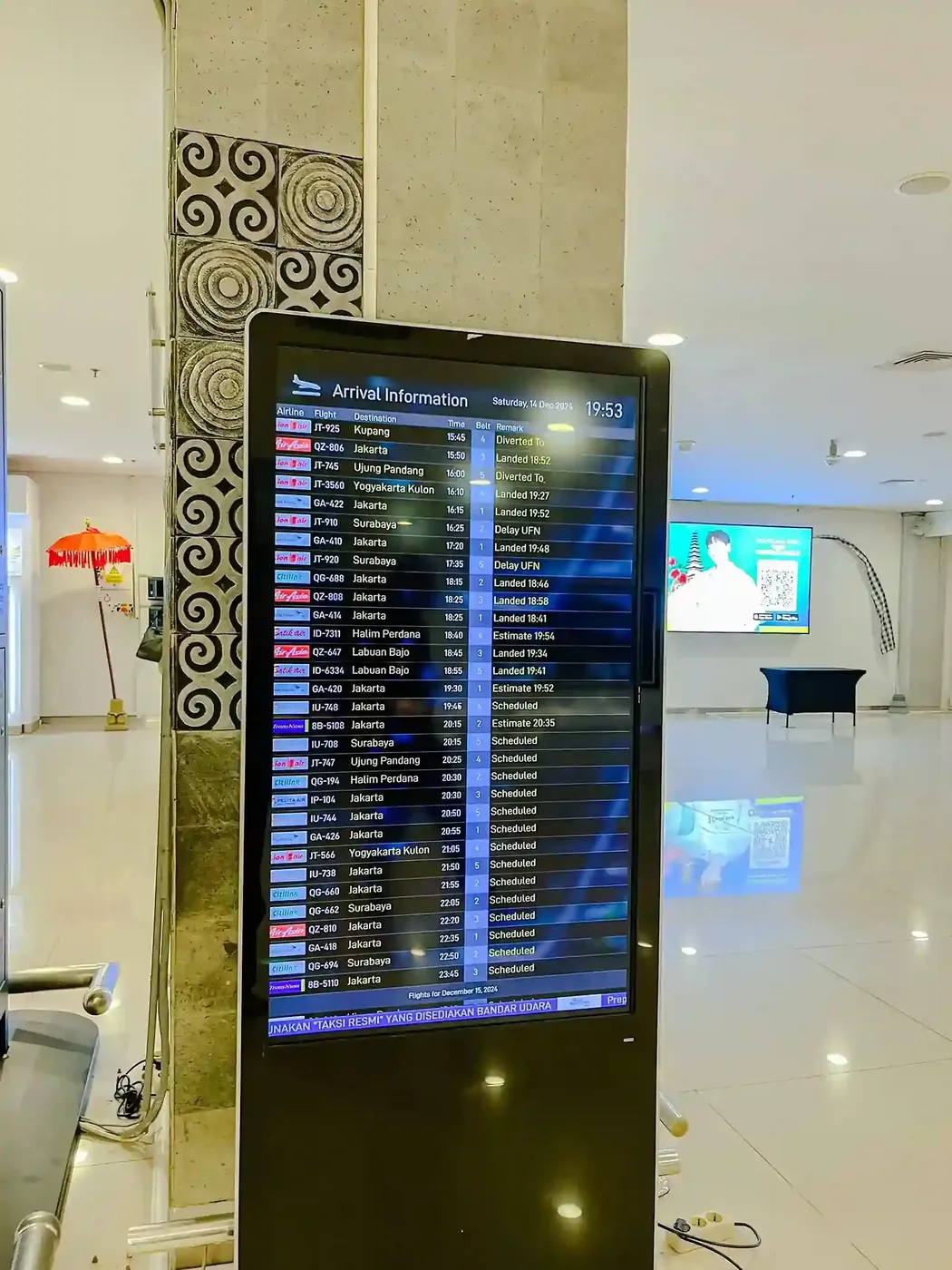 A flight information display inside the Ngurah Rai terminal